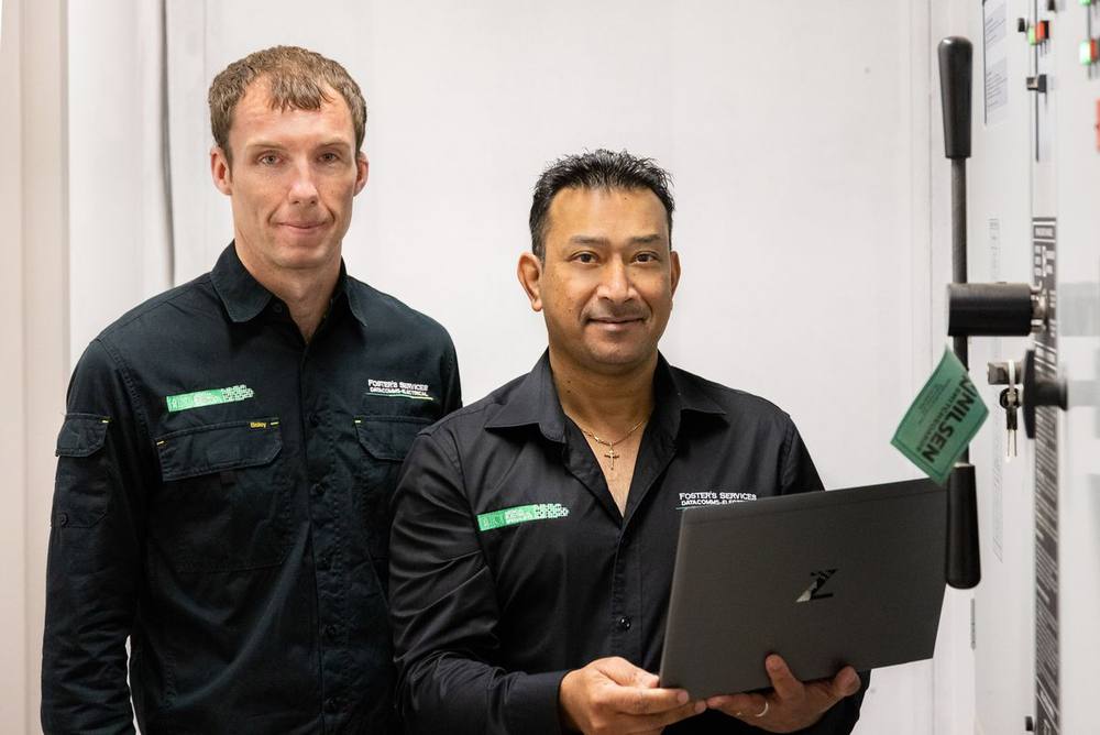 Two Foster’s technicians reviewing a laptop on site